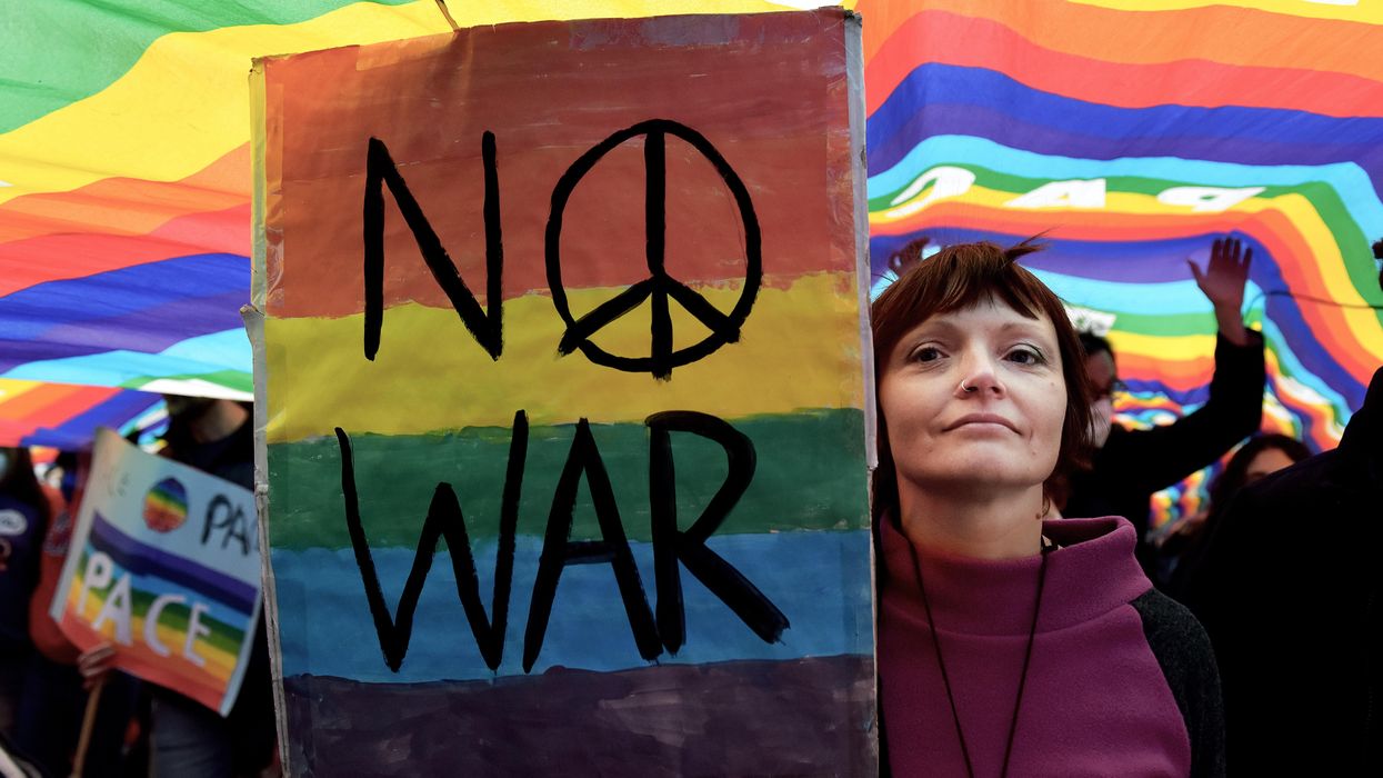 Women holds sign that reads "No War" to protest war in Ukraine