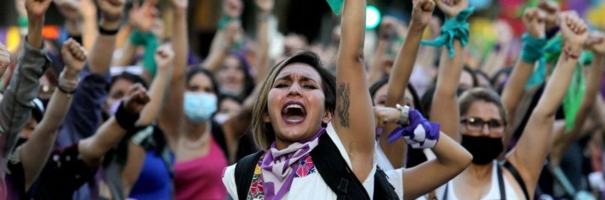 Women raise their fists during a demonstration to mark International Women's Day
