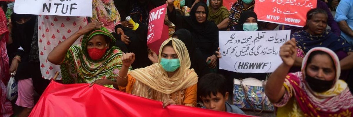 Women with raised fists protest the IMF in Pakistan. 