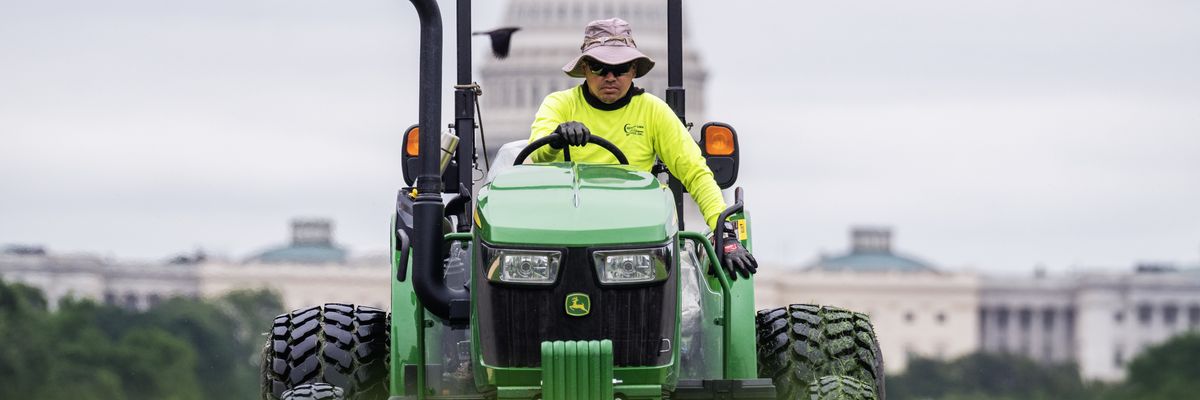 Worker mows grass on National Mall