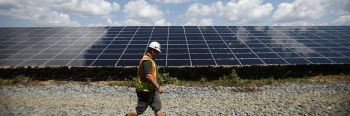 Worker walking by solar array