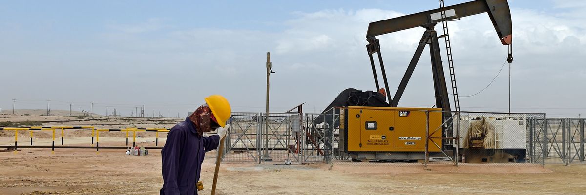 Worker with pump jack in Bahrain oil field. 