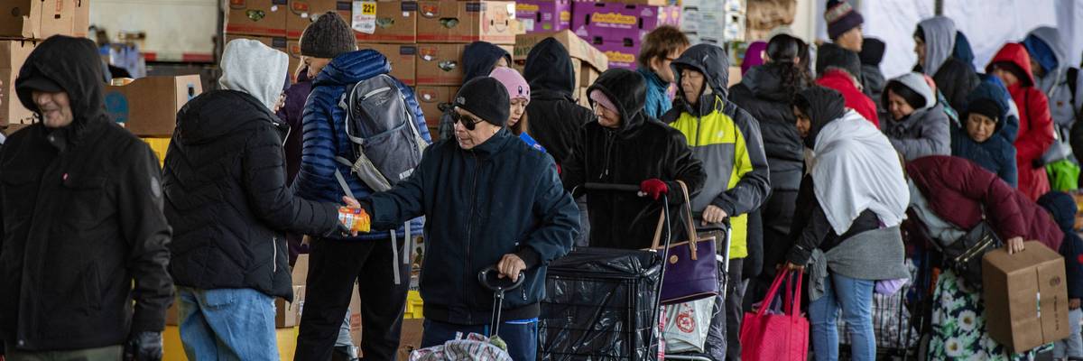 Workers and volunteers hand out food at a food pantry