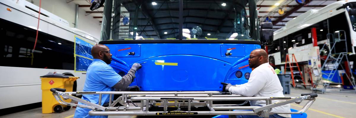 Workers build an electric bus at a factory in Lancaster, California on May 1, 2018.