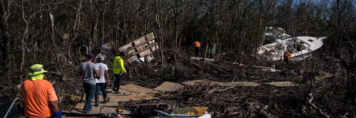 Workers clear out debris off San Carlos Boulevard in Fort Myers Beach, Florida