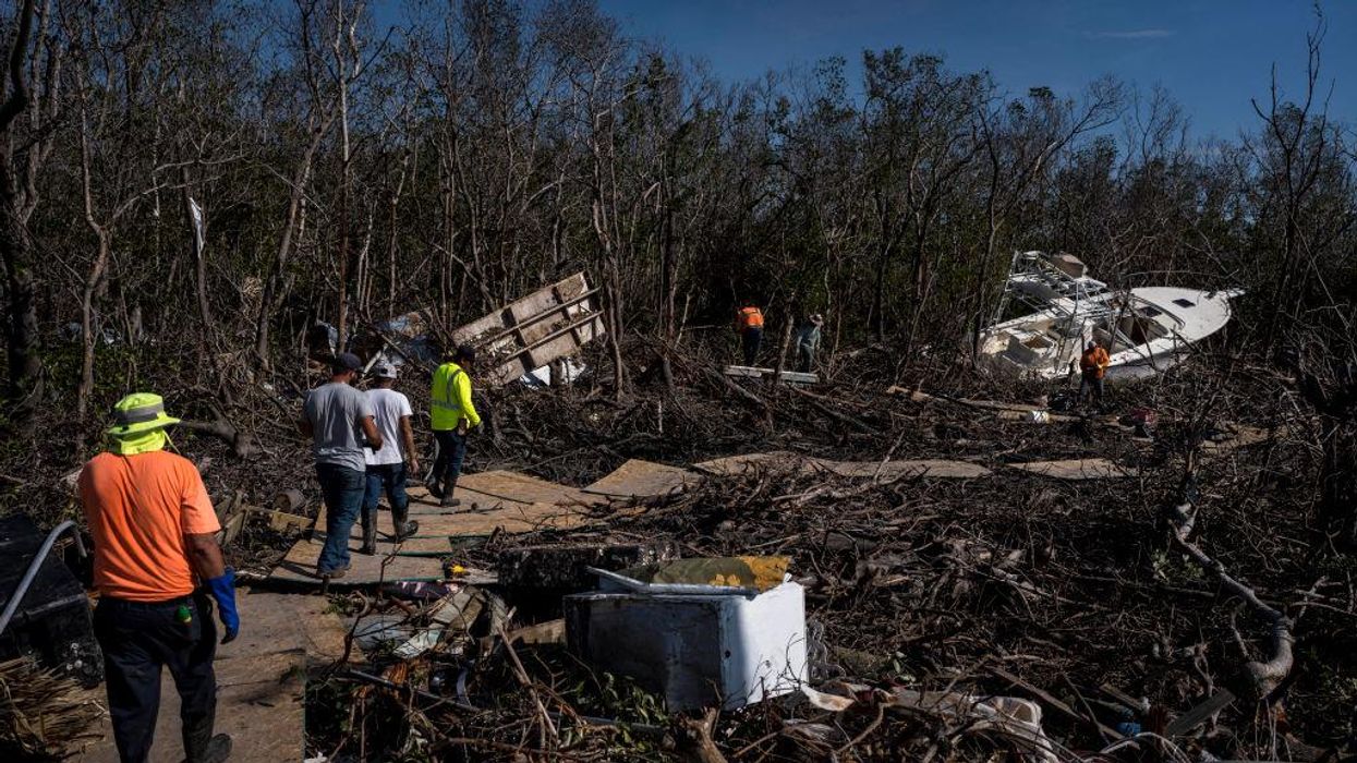 Workers clear out debris off San Carlos Boulevard in Fort Myers Beach, Florida