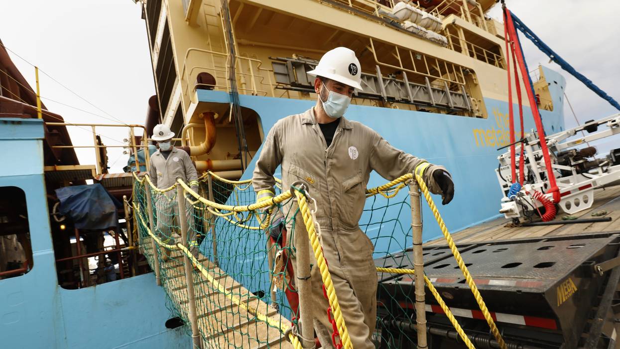 Workers disembark from a research vessel