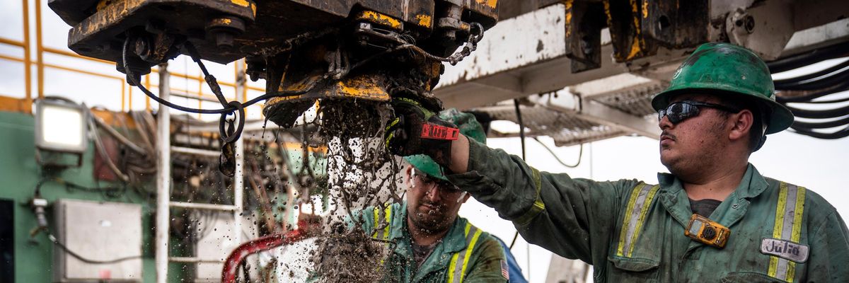 Workers extract oil from a well in the Permian Basin
