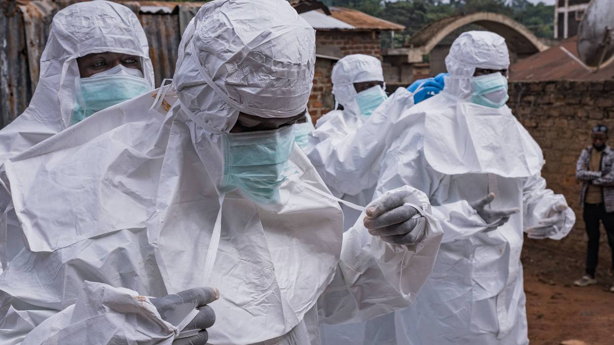 Workers from the Uganda Red Cross Society don protective suits