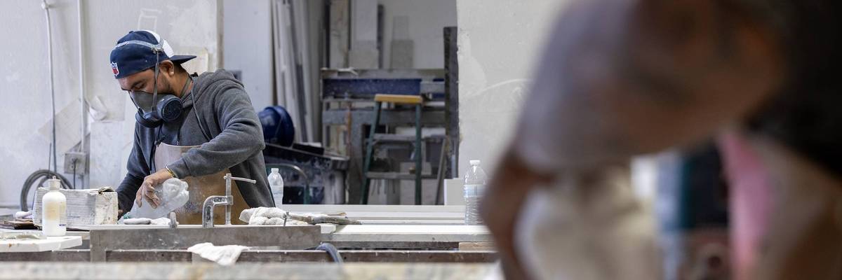 Workers grind and polish stone for countertops 1