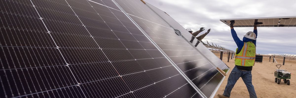 Workers install solar panels for the Los Angeles Department of Water and Power's biggest solar and battery storage plant