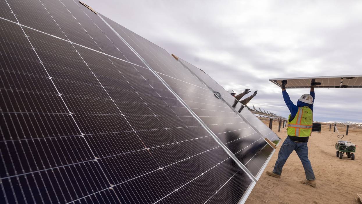 Workers install solar panels for the Los Angeles Department of Water and Power's biggest solar and battery storage plant