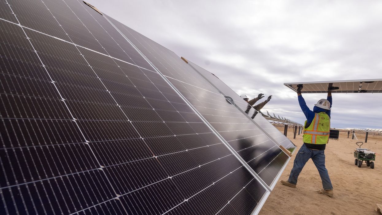 Workers install solar panels for the Los Angeles Department of Water and Power's biggest solar and battery storage plant