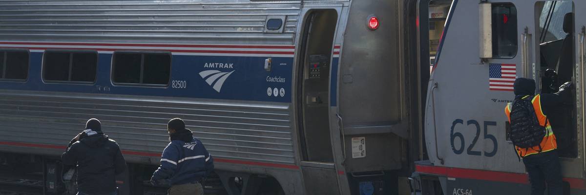 Workers on an Amtrak platform.