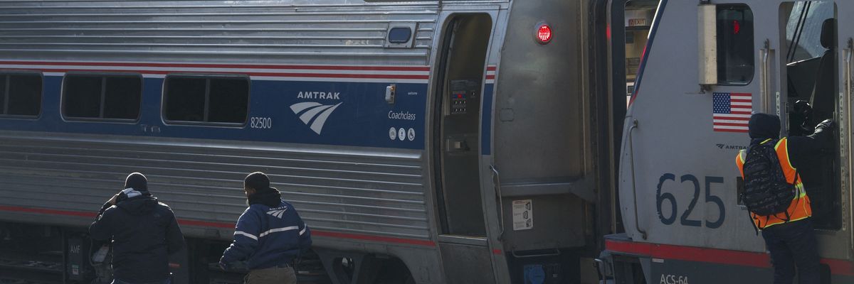 Workers on an Amtrak platform.