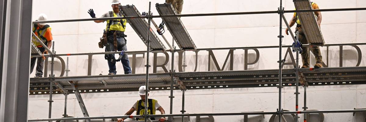 Workers prepare to remove Trump's name from the Kennedy Center