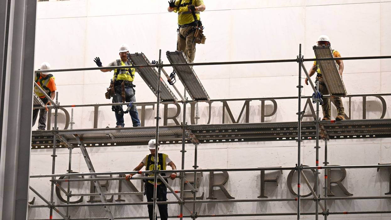 Workers prepare to remove Trump's name from the Kennedy Center