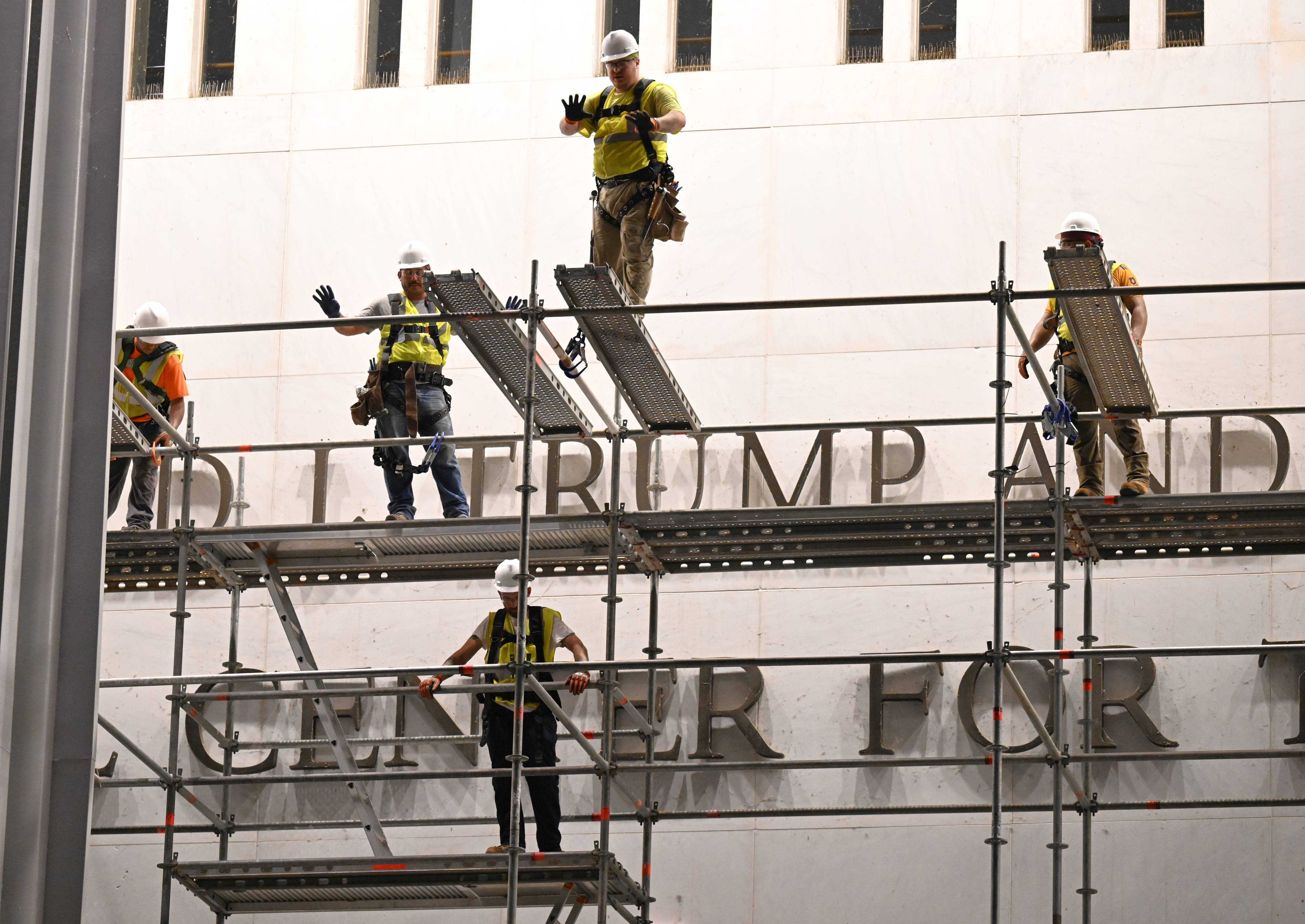 Workers prepare to remove Trump's name from the Kennedy Center