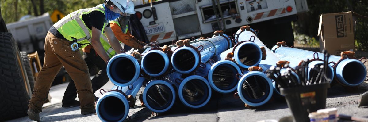 workers stack water pipes