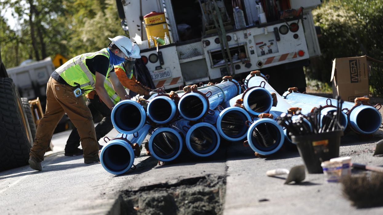 workers stack water pipes