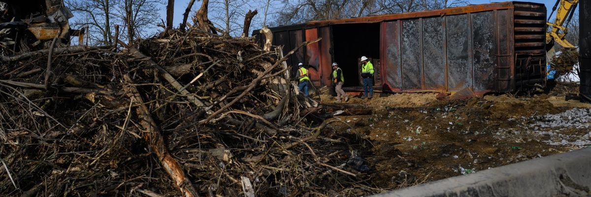 Workers survey the damage from a train derailment