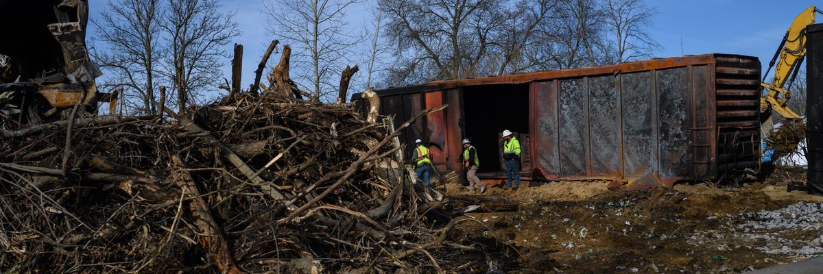 Workers survey the damage from a train derailment 
