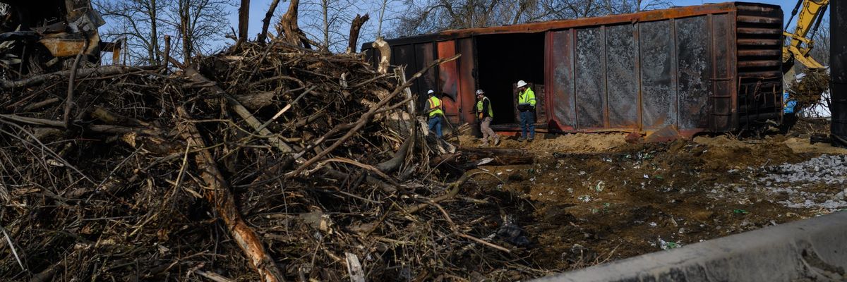 Workers survey the damage from a train derailment 
