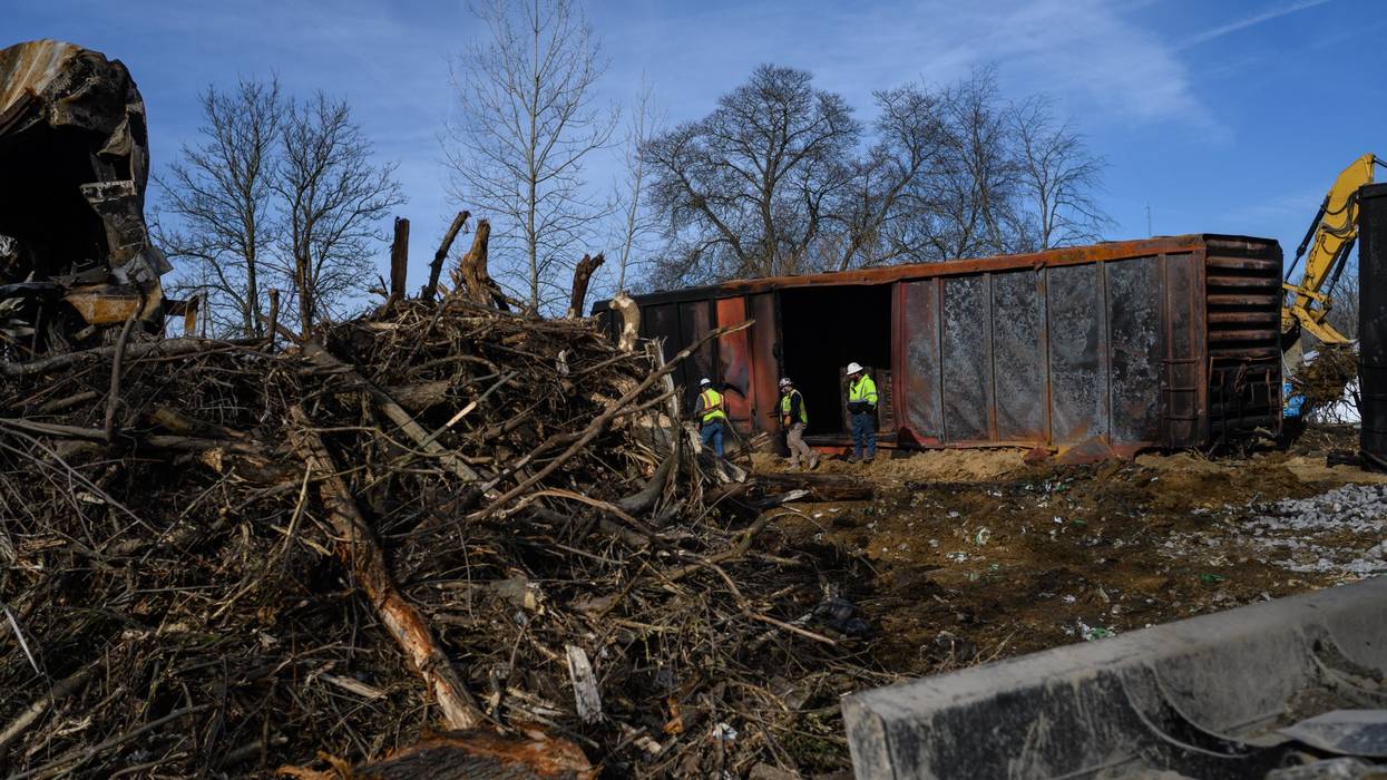 Workers survey the damage from a train derailment