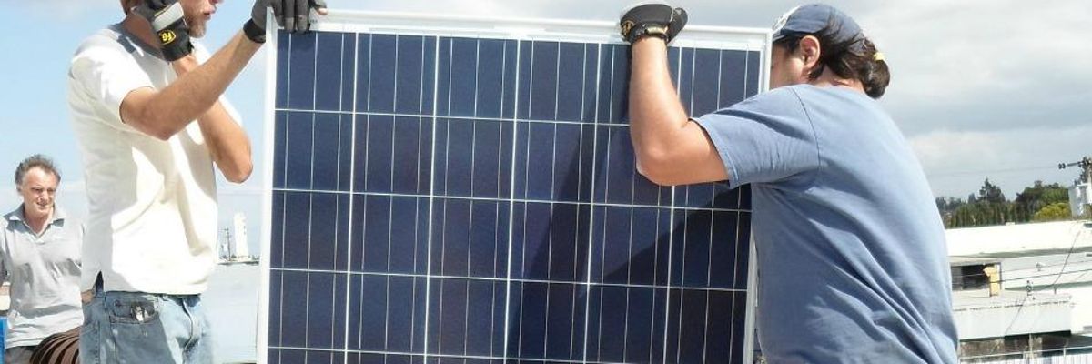 Workers with San Francisco-based Everybody Solar install a photovoltaic system