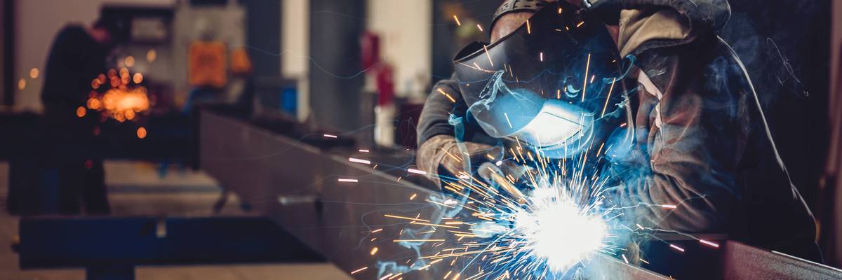 working class Industrial Welder With Torch and Protective Helmet