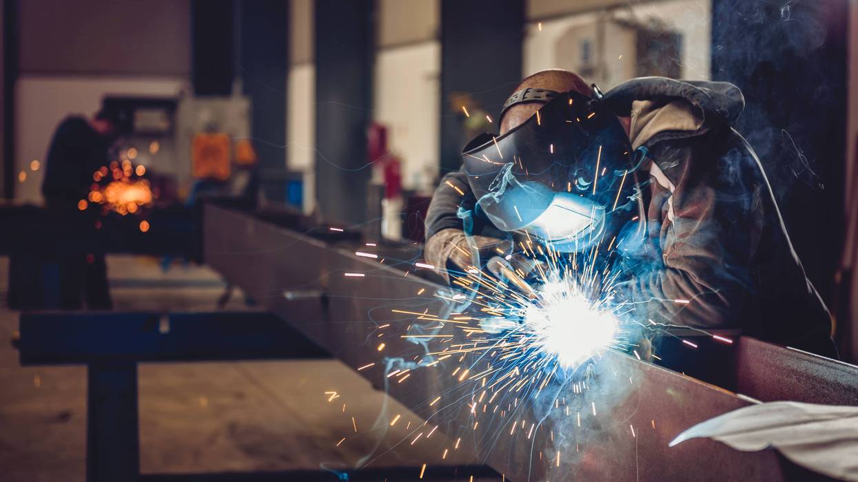 working class Industrial Welder With Torch and Protective Helmet