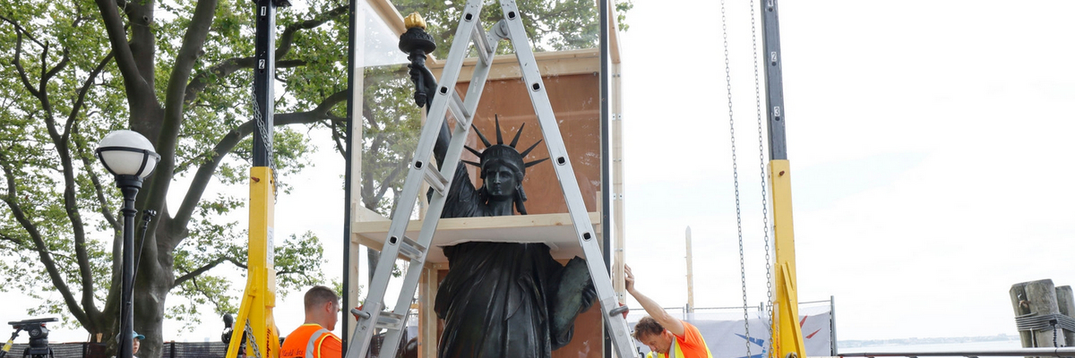 Workmen uncrate the "Little Sister" of the Statue of Liberty, a 9-foot-tall bronze statue, crafted from the original 1878 plaster model by Auguste Bartholdi.