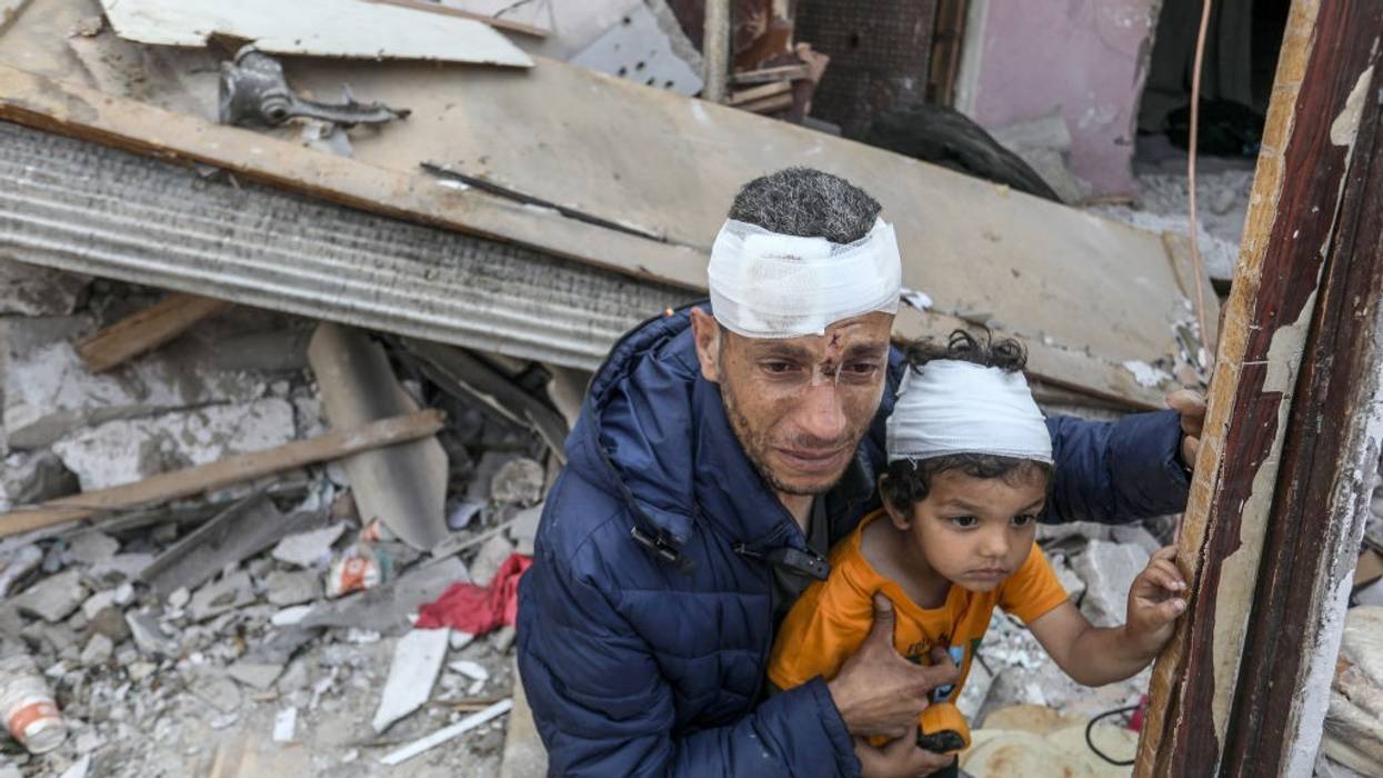 Wounded Palestinians amid the rubble of destroyed homes in Rafah