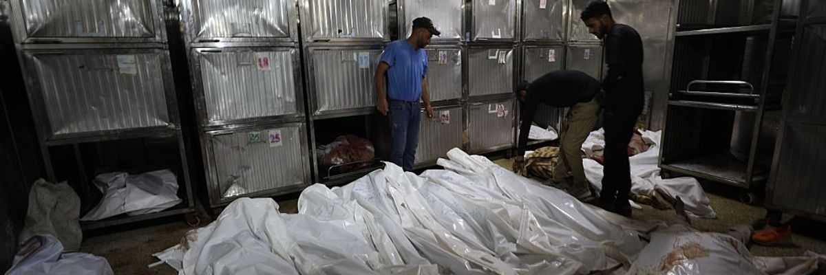 Wrapped bodies of Palestinians killed by Israel in Gaza pile up in a morgue