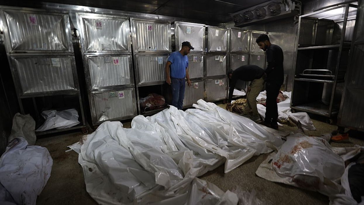 Wrapped bodies of Palestinians killed by Israel in Gaza pile up in a morgue