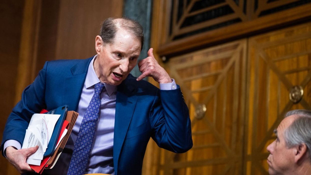 Wyden holds hands up like he's making a phone call