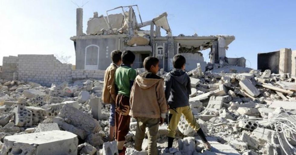 Yemeni children stand in front of a building destroyed by airstrikes. (Photo: Yahya Arhab/EPA)