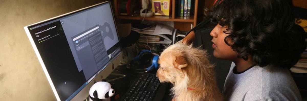 Young boy and his dog looking at internet on a computer
