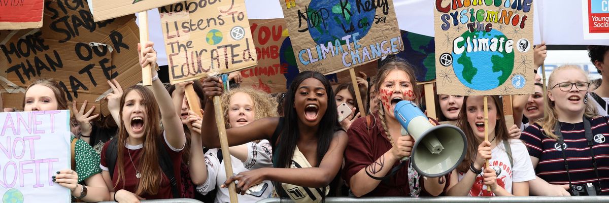 Young climate protesters hold signs in London