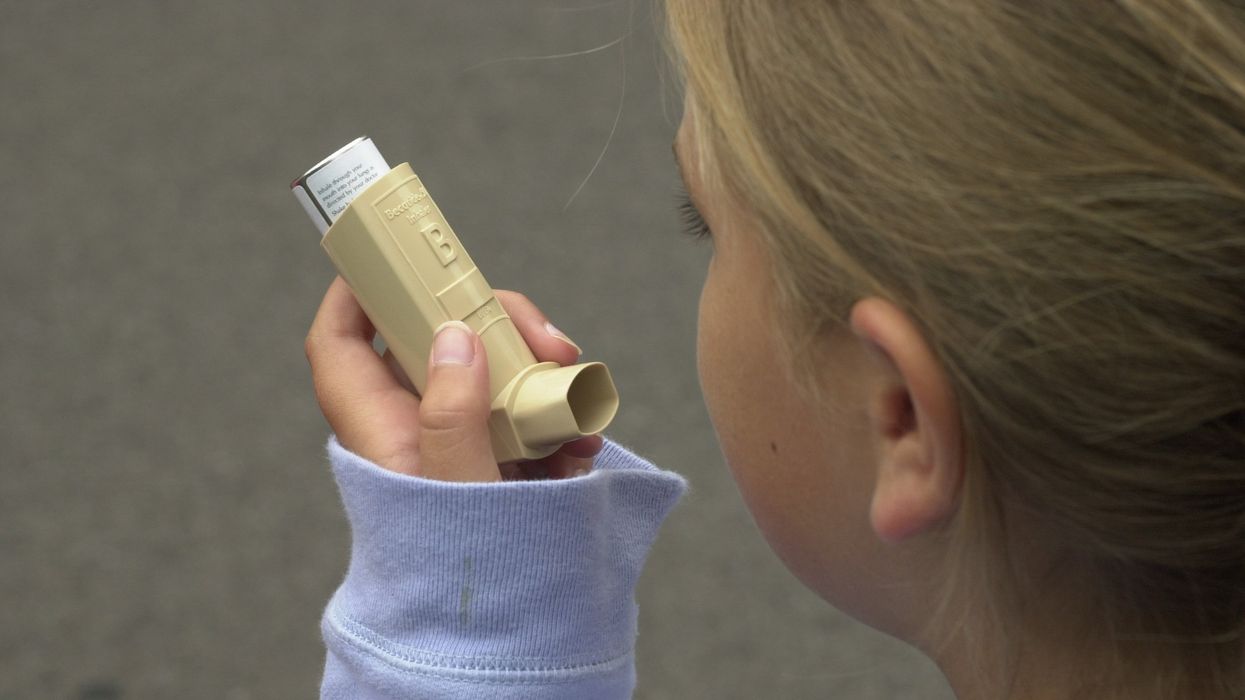 Young girl using asthma inhaler.