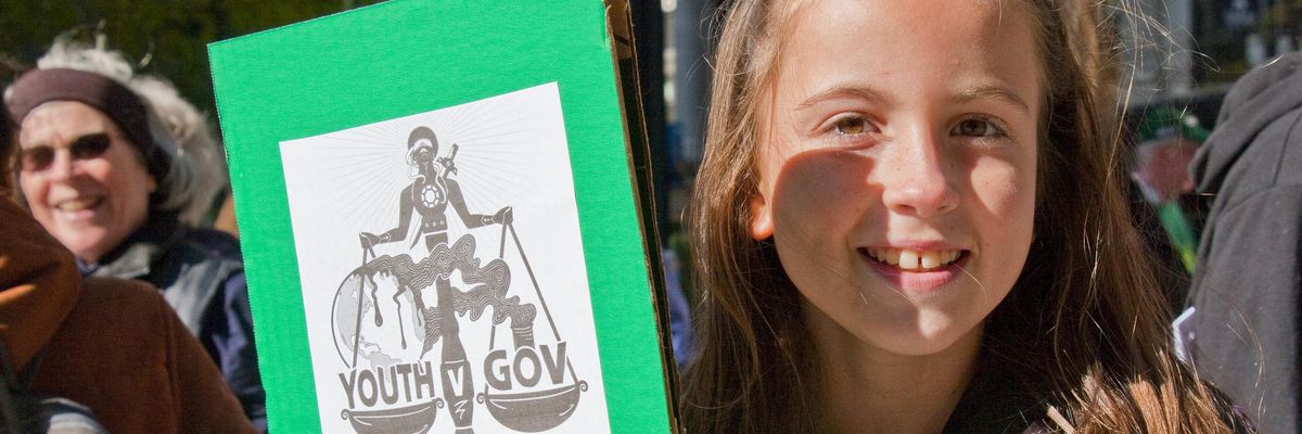 Youth protesters holds sign in support of youth climate plaintiffs
