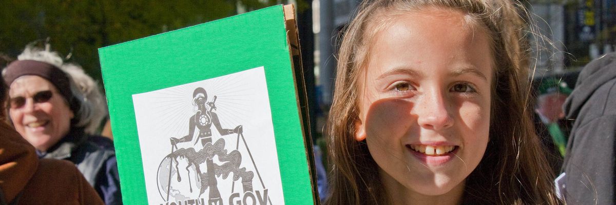 Youth protesters holds sign in support of youth climate plaintiffs