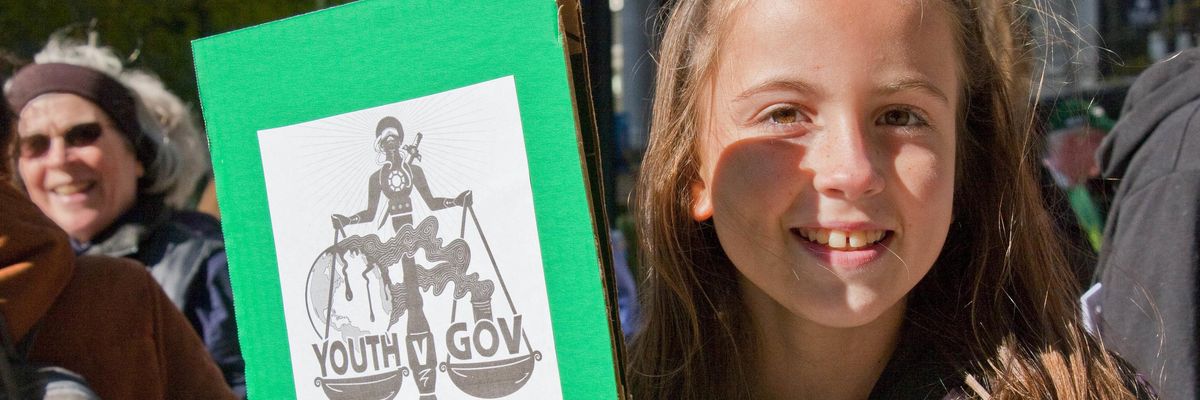 Youth protesters holds sign in support of youth climate plaintiffs