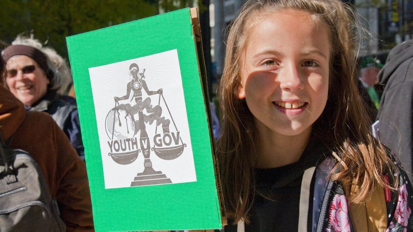 Youth protesters holds sign in support of youth climate plaintiffs