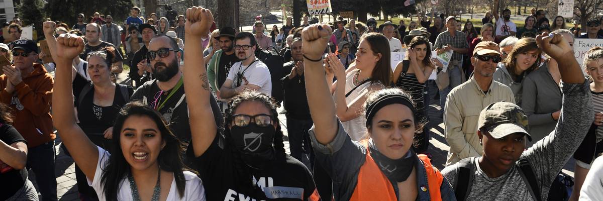 Youth protesters put up their fists as they participate in a youth rally