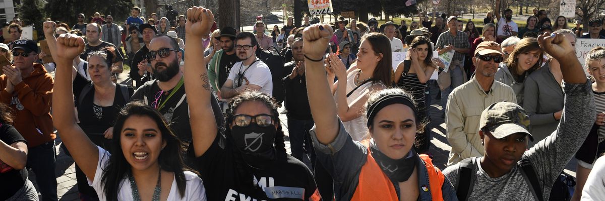 Youth protesters put up their fists as they participate in a youth rally