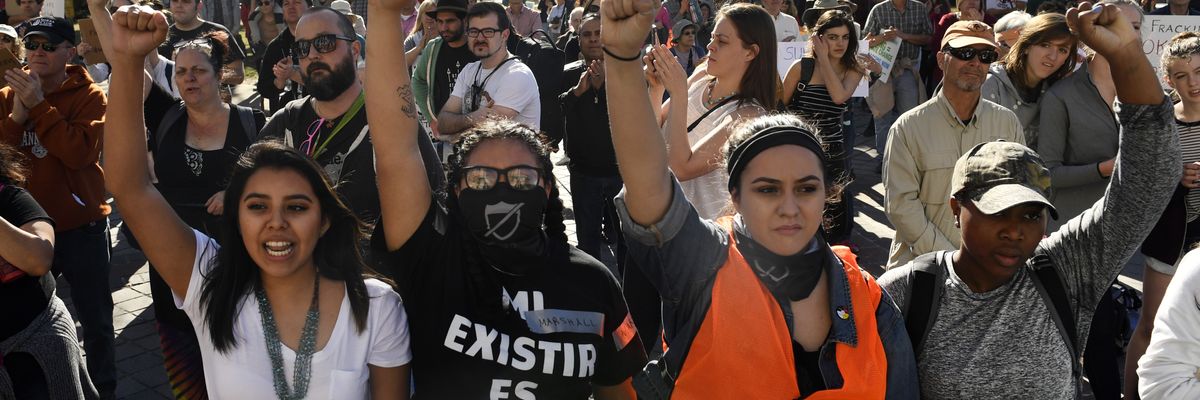 Youth protesters put up their fists as they participate in a youth rally 