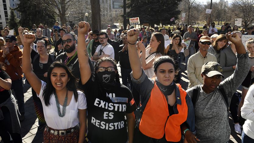 Youth protesters put up their fists as they participate in a youth rally