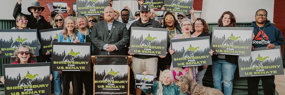 Zach Shrewsbury surrounded by campaign flyers and supporters.