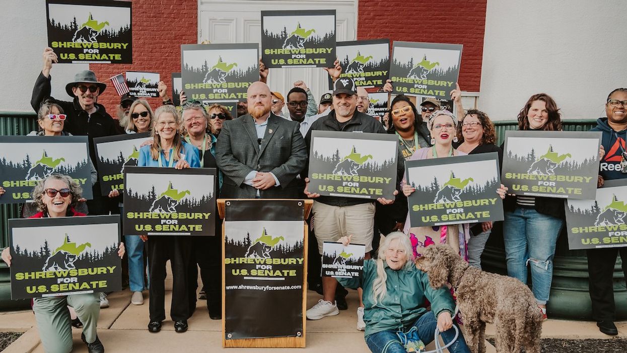 Zach Shrewsbury surrounded by campaign flyers and supporters.